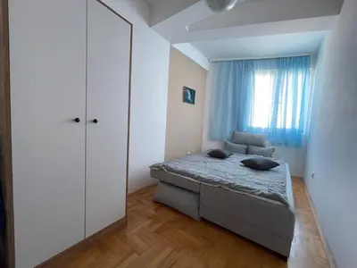 a small bedroom with a bed and a window at Sedmi Juli in Niš