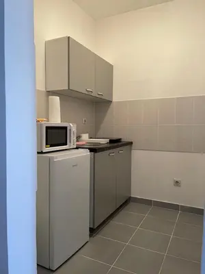 a kitchen with a microwave and a refrigerator at Sedmi Juli in Niš