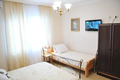 a small room with two beds and a window at Royal Apartments in Niš