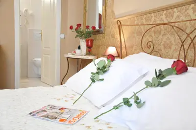 a bedroom with a bed with two roses on it at Royal Apartments in Niš