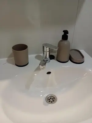 a white sink with a soap dispenser on it at AN Jezero-Apartman Jaki 12 in Vrnjačka Banja