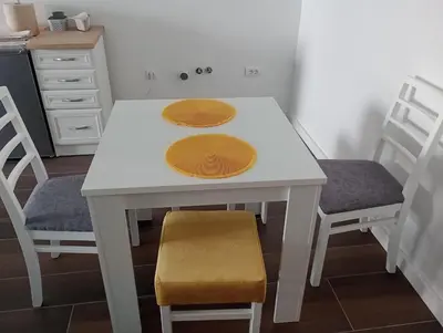 a white table with two chairs and a kitchen at AN Jezero-Apartman Jaki 12 in Vrnjačka Banja