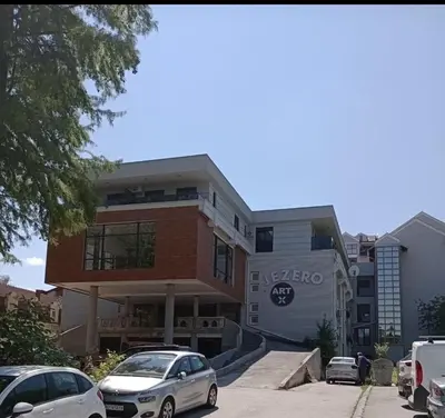 a building with cars parked in front of it at AN Jezero-Apartman Jaki 12 in Vrnjačka Banja