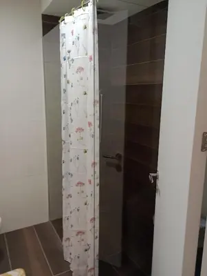 a shower curtain with flowers on it in a bathroom at AN Jezero-Apartman Jaki 12 in Vrnjačka Banja