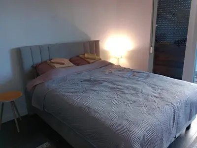 a bedroom with a bed with a lamp and a table at AN Jezero-Apartman Jaki 12 in Vrnjačka Banja