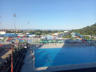 a swimming pool with a bunch of people sitting around it at Aqua Park Lux Jagodina in Trnava