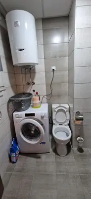 a small bathroom with a washing machine and a toilet at Aqua Park Lux Jagodina in Trnava