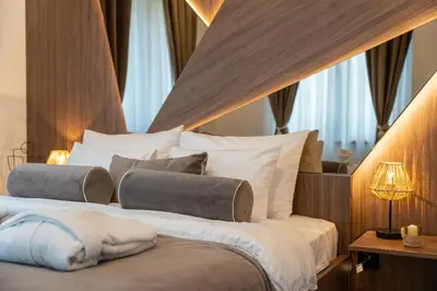 a bedroom with a large bed with white sheets and pillows at Apartman Riva in Vrnjačka Banja