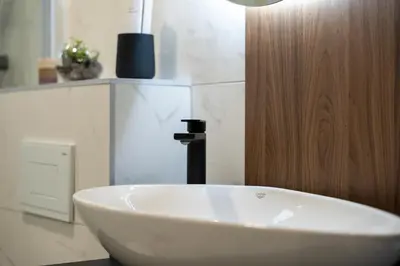a bathroom with a white sink and a faucet at Apartman Riva in Vrnjačka Banja