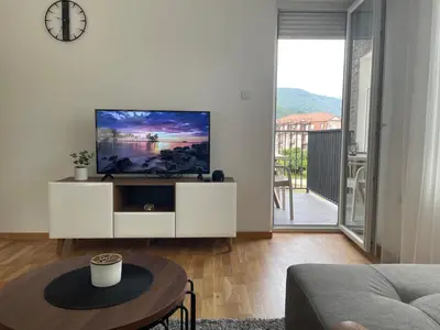 a living room with a tv on a white cabinet at Apartman Dolce Vita Sokobanja in Soko Banja