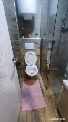 a bathroom with a toilet and a shower with a purple rug at La Vie En Rose - Milmari Resort in Kopaonik