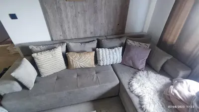 a gray couch with several pillows on it at La Vie En Rose - Milmari Resort in Kopaonik
