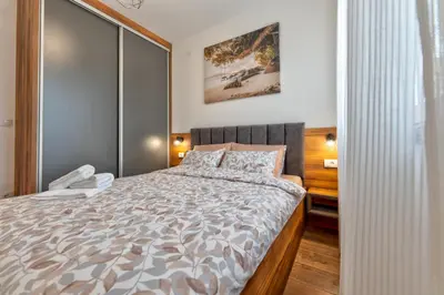 a bedroom with a large bed in a room at Contigo Apartman Vrnjacka Banja - Vrnjacka promenada in Vrnjačka Banja