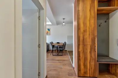 a hallway leading to a dining room with a table at Contigo Apartman Vrnjacka Banja - Vrnjacka promenada in Vrnjačka Banja