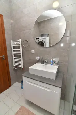 a bathroom with a white sink and a mirror at Apartman Dina in Pirot