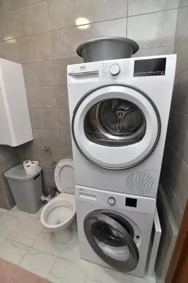 a washer and dryer in a bathroom with a toilet at Apartman Dina in Pirot