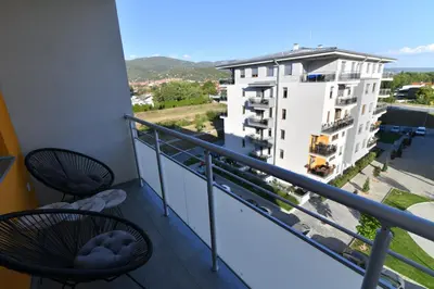 a balcony with chairs and a view of a building at Apartman Dina in Pirot