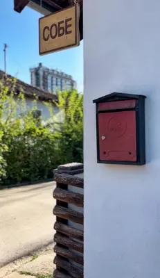 a red box on the side of a building with a sign at Smeštaj Pejčić in Niška Banja