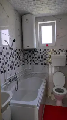 a bathroom with a tub and a toilet and a sink at Domaćinsvo Stević - Sekurič in Belušić
