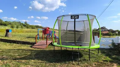 a playground in a field next to a body of water at Domaćinsvo Stević - Sekurič in Belušić