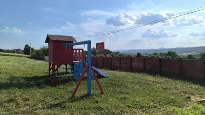 a playground in a yard with a playset at Domaćinsvo Stević - Sekurič in Belušić