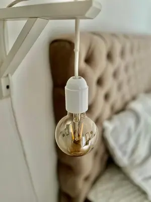 a glass light hanging from a wall next to a bed at Skandik Luxe Residence in Jagodina