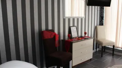 a bedroom with a dresser and a chair and a desk at Hotel Saradis in Kruševac