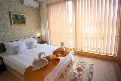 a bedroom with a bed with two swans on it at Hotel Saradis in Kruševac