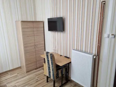 a wooden table with a chair and a television on a wall at Hotel Saradis in Kruševac