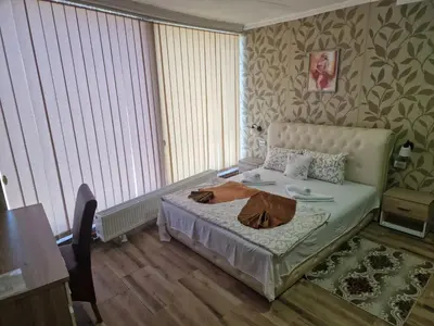 a bedroom with a bed and a table with a coat on it at Hotel Saradis in Kruševac