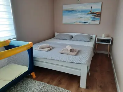 a small bedroom with a bed with towels on it at Dream Home, FREE GARAGE in Niš