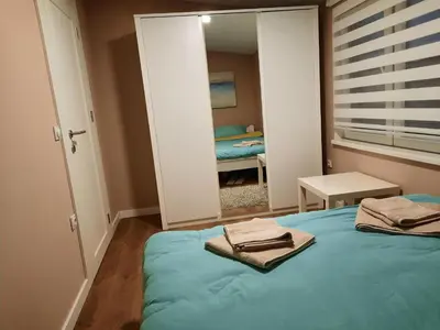 a bedroom with a blue bed and a mirror at Dream Home, FREE GARAGE in Niš
