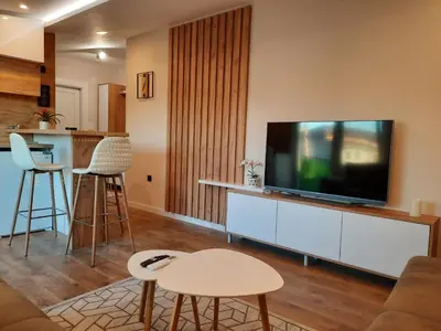 a living room with a flat screen tv on a cabinet at Dream Home, FREE GARAGE in Niš