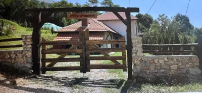 a wooden gate in front of a building with a fence at Etno Dušnik in Gadžin Han