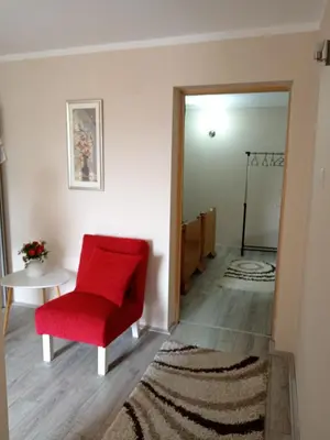 a red chair and a table in a room at Etno Dušnik in Gadžin Han