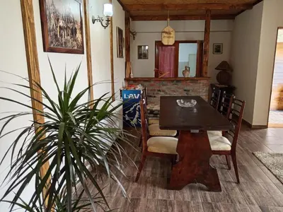 a dining room with a table and chairs and a plant at Etno Dušnik in Gadžin Han