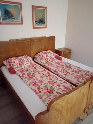 a bedroom with a wooden bed with flowers on it at Etno Dušnik in Gadžin Han