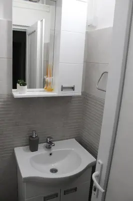a bathroom with a white sink and a mirror at Apartman Denčić Zavojsko jezero in Pirot