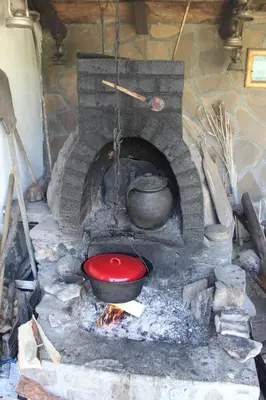 a stone oven with a pot and a red bowl at Apartman Denčić Zavojsko jezero in Pirot