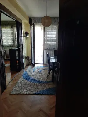 a dining room with a table and a rug at Apartman Sofka in Vranje