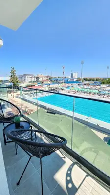 a balcony with two chairs and a swimming pool at apartman gold Jagodina in Jagodina