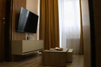 a living room with a flat screen tv and a table at apartman gold Jagodina in Jagodina