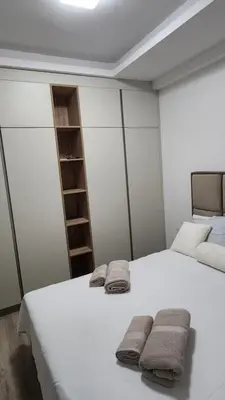 a bedroom with a large white bed with towels on it at apartman gold Jagodina in Jagodina
