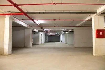 an empty parking garage with white walls and red beams at Vasilije in Vrnjačka Banja