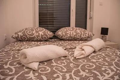a bed with two pillows and two towels on it at Vasilije in Vrnjačka Banja