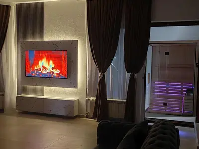 a living room with a fire in a fireplace at Hedonic Wellness Apartmani in Niš
