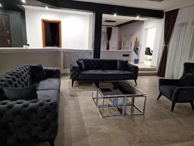a living room with couches and a coffee table at Hedonic Wellness Apartmani in Niš