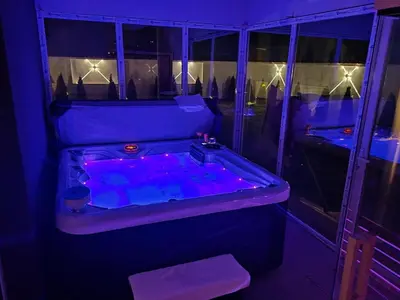 a bath tub with purple lighting in a room at Hedonic Wellness Apartmani in Niš