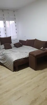 a bedroom with a large bed and a couch at Apartman Vanja in Paraćin