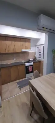 a kitchen with wooden cabinets and a wooden table at Apartman Vanja in Paraćin